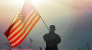Persona militar ondeando una bandera estadounidense